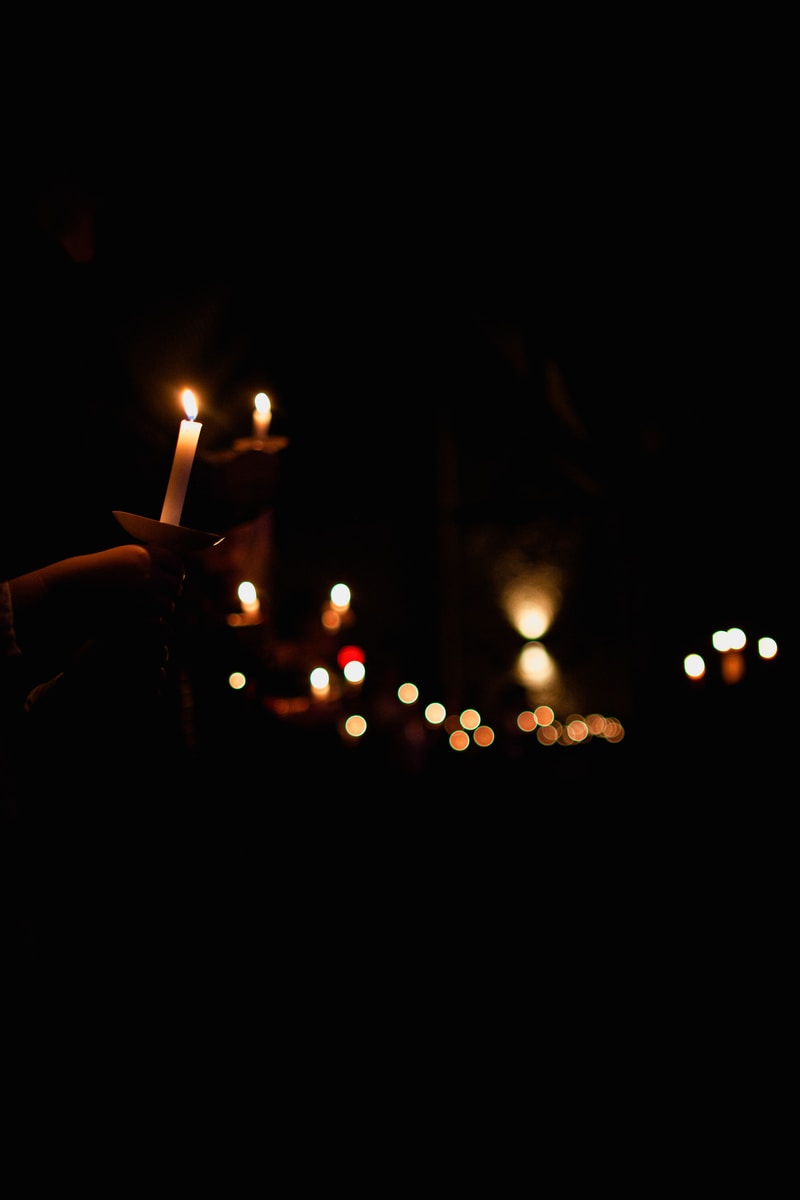 person holding lighted candle during night time